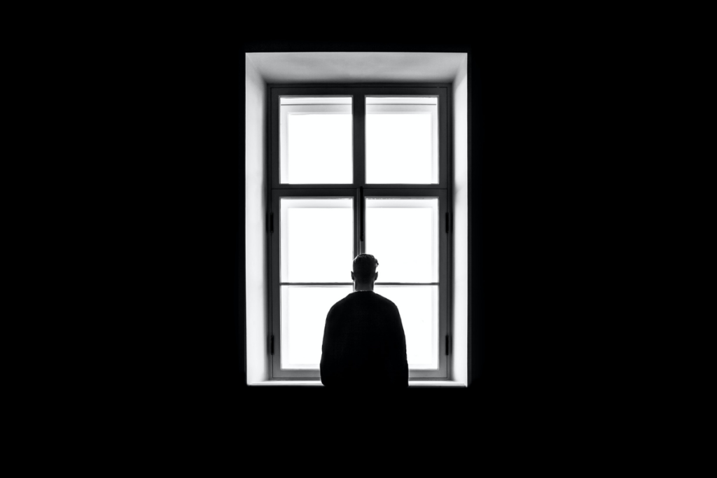 a man in isolation looks out of his window during the COVID quarantine as discussed in the corresponding letter