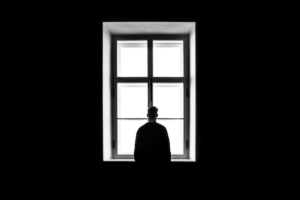 a man in isolation looks out of his window during the COVID quarantine as discussed in the corresponding letter