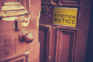 An eviction notice posted to a wooden door selected to accompany a letter written to a painful condition at www.DearDiagnosis.com